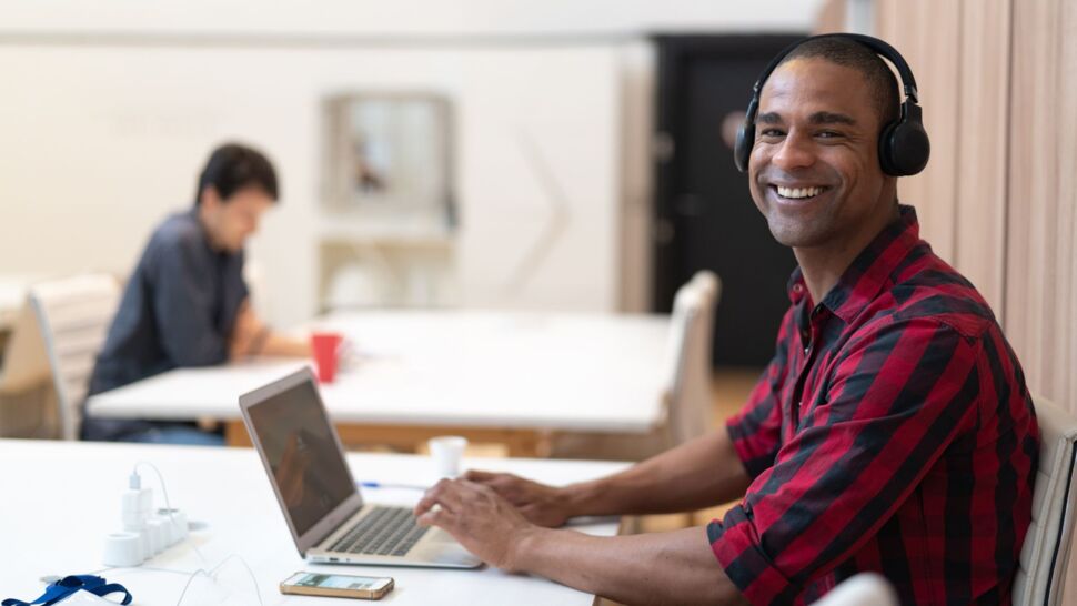 man-working-with-headphones-smiling-at-camera
