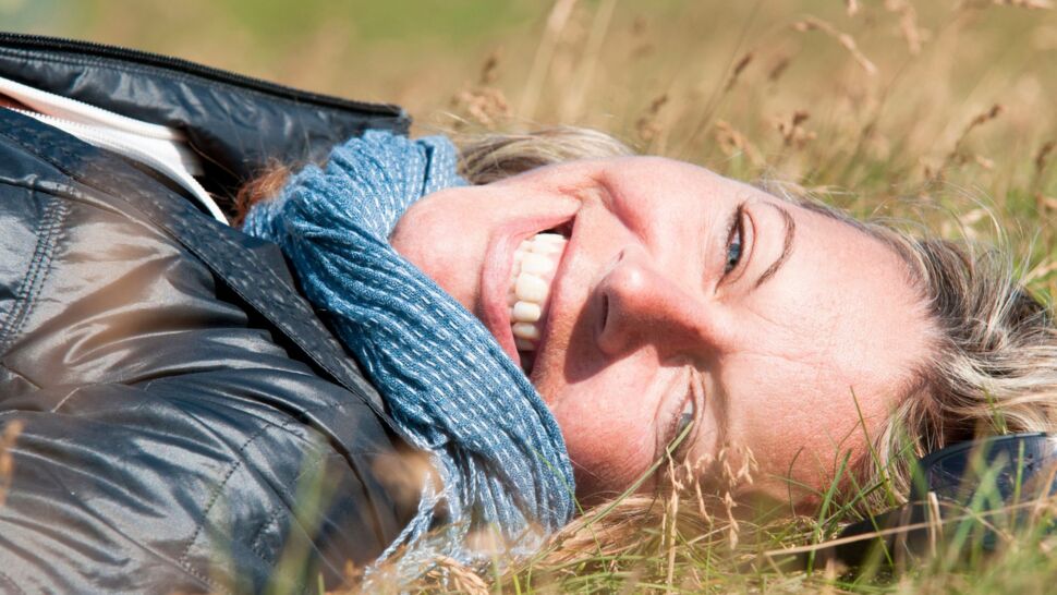 woman-lying-in-grass-smiling-at-camera