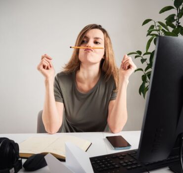 woman-procrastinating-behind-desk