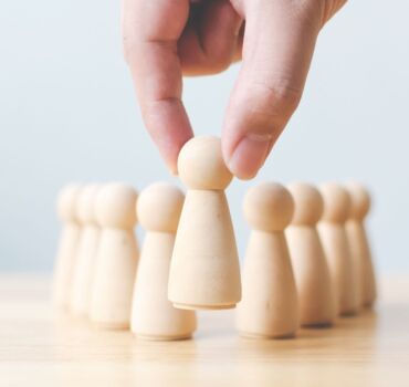 man-placing-wooden-pawn-in-front-others