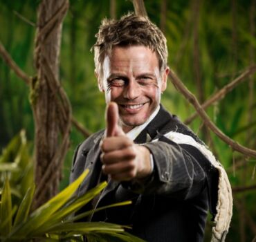 man-with-torn-up-suit-in-jungle-raising-thumb man-with-torn-up-suit-in-jungle-raising-thumb
